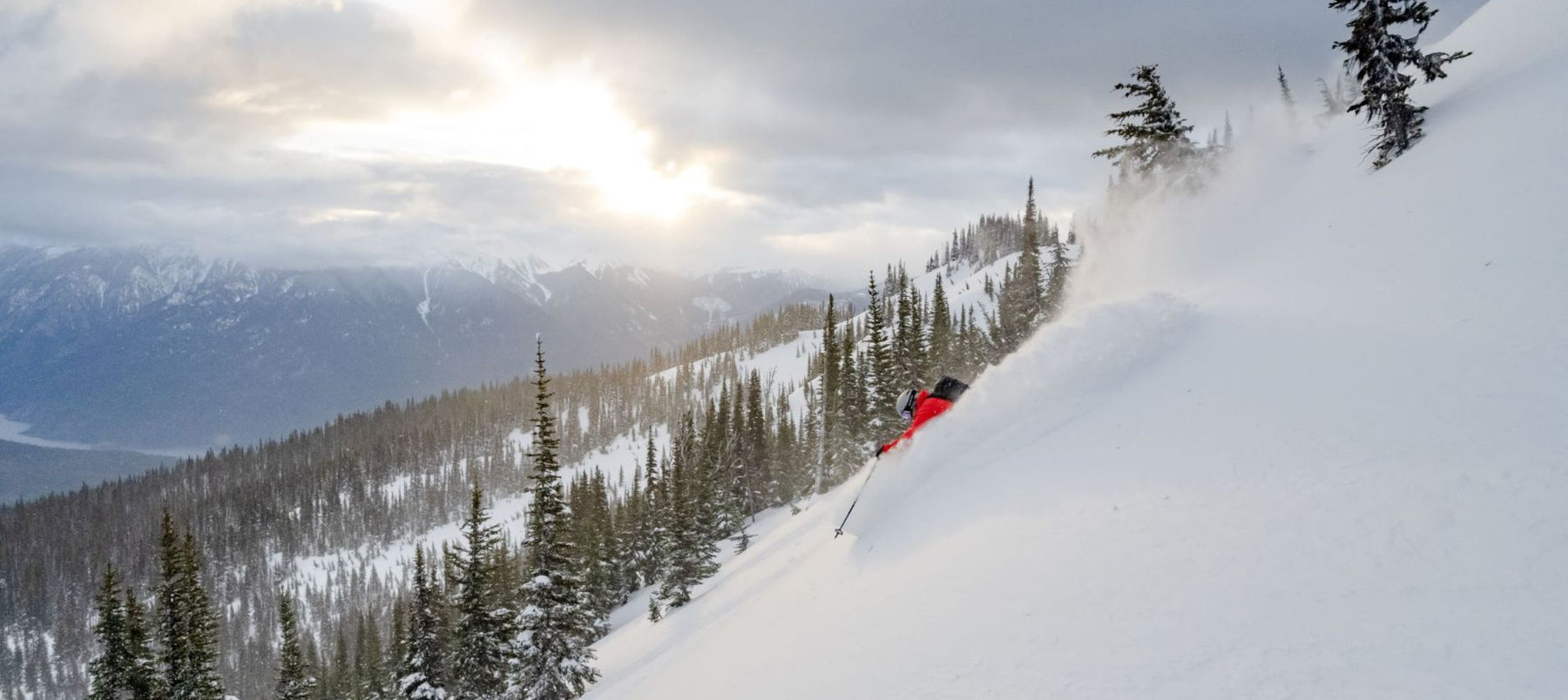 downhill skiing with sun breaking through clouds